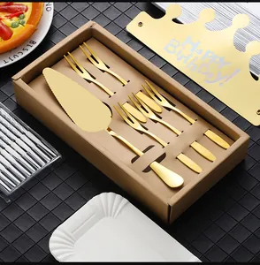 Macro detail of gold stainless steel cake server and forks in a premium gift box
