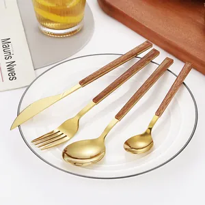 Elegant 4-piece gold stainless steel cutlery set with wood grain handles on white plate
