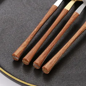 430 stainless steel cutlery set with wood-grain handles on a black matte plate