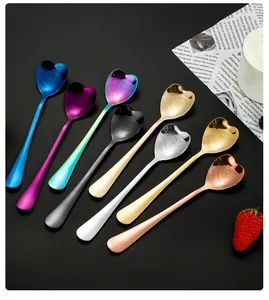 Macro detail of heart-shaped stainless steel spoons with Happy Family engraving