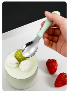Macro shot of a child's stainless steel spoon with a light green ergonomic handle