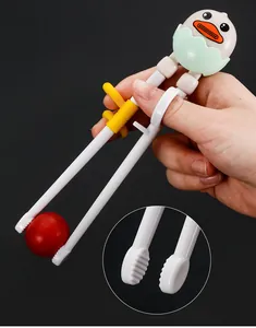 Detail of baby training chopsticks with duck topper and ergonomic finger rings for grip