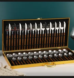Détail du service de couverts 24 pièces en acier et bois dans un coffret cadeau doré