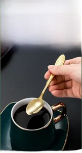 Détail de la cuillère dorée en acier inoxydable martelé au design ergonomique monobloc