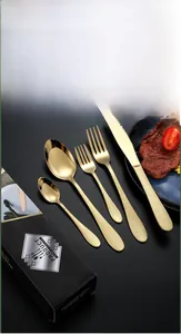 Vue détaillée d'un ensemble de couverts en acier martelé doré dans un coffret cadeau noir