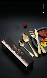 Close-up of golden stainless steel cutlery set presented in a sleek black gift box