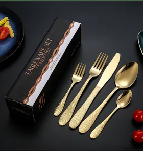 Détail d'un ensemble de couverts en acier inoxydable doré martelé dans un coffret cadeau