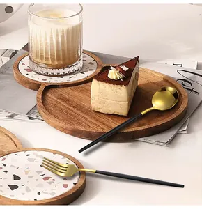 Gros plan d'un ensemble de couverts en inox noir et or sur un plateau en bois