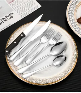 Detailed close-up of mirror-polished stainless steel cutlery set with black handles
