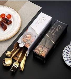 Detail of 24-piece golden stainless steel cutlery set partially out of elegant black gift box