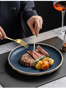 Detail van een elegante gouden roestvrijstalen bestekset op een dinerbord