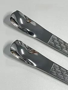 Détail du manche de cuillère en inox avec texture de nervure de feuille et poli miroir