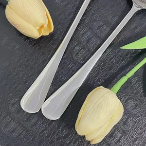 Dettaglio di cucchiai in acciaio inossidabile lucidato a specchio con manico lungo nero