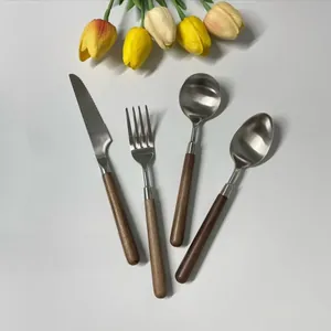 Detail of 4-piece 304 stainless steel cutlery set with walnut wooden handles on white