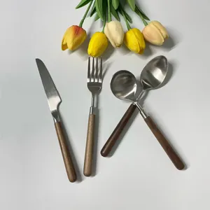 4-piece stainless steel cutlery set with walnut wood handles on a white background