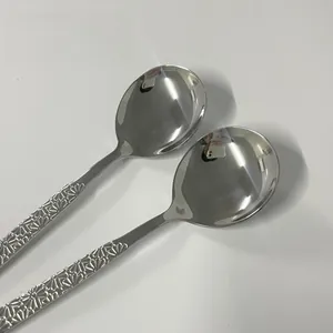 Detail of round 304 stainless steel spoons with floral engraved handles and mirror finish