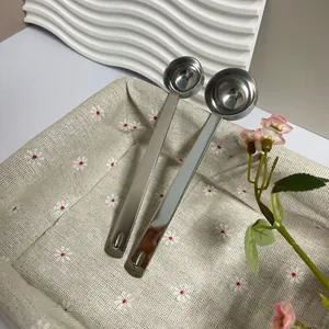Gros plan de deux cuillères à mesurer en inox avec long manche dans un panier