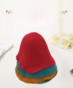 Empilement vertical de formes de chapeaux en feutre de laine en rouge, bleu et jaune
