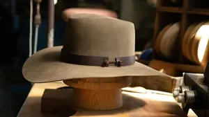 Detalle de sombrero de vaquero en fieltro de lana con banda de cuero en soporte