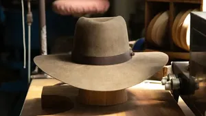 Detalle de sombrero de vaquero en fieltro de lana marrón con banda de cuero en madera