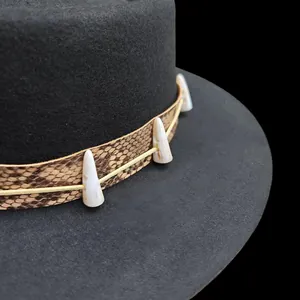 Detail of black wool fedora featuring snake print band and unique tusk ornaments