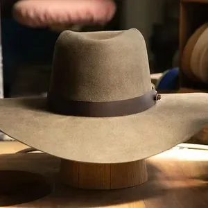 Sombrero vaquero de fieltro de lana verde salvia con banda de cuero marrón y soporte madera