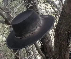 Détail d'un chapeau boléro en laine noire avec bande tissée et branches