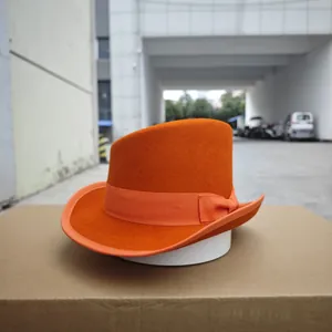 Detail of orange wool felt boater hat with matching grosgrain ribbon and bow decoration