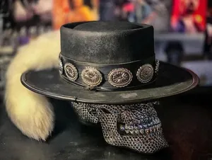 Détail d'un chapeau en laine noir avec bande de concho en argent et queue en fourrure