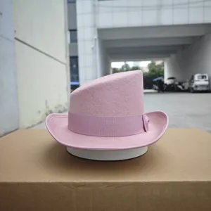 Detail of pink wool felt fedora with diagonal top and silk ribbon on white stand