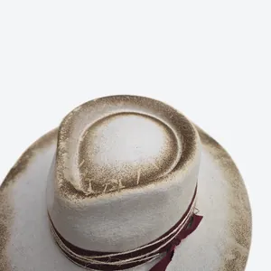 Top view of vintage teardrop wool felt hat with burnt edges and red ribbon decor