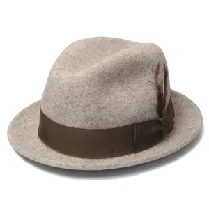 Detailed close-up of wool fedora hat featuring brown grosgrain ribbon and feather accent