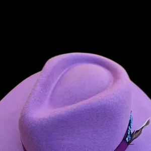 Dettaglio cappello in feltro di lana viola con nastro e decorazione in piuma naturale