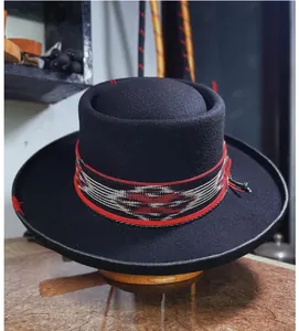 Detail of flat top wool felt hat featuring tribal woven band and delicate red stitching