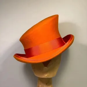 Artistic orange wool felt top hat with asymmetrical crown and red satin ribbon band