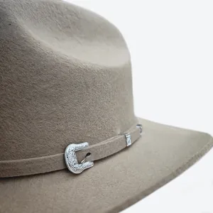 Detailed close-up of khaki wool felt western hat featuring an ornate silver metal buckle