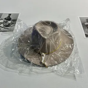 Dettaglio cappello in lana kaki con cordino dorato all'interno della confezione protettiva