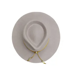 Vista piatta di un cappello di lana grigio chiaro con filo d'oro e perline metalliche