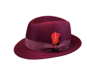 Dettaglio di fedora in lana bordeaux con nastro in gros-grain e piuma rossa decorativa