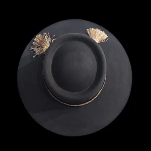 Dettaglio del cappello in feltro di lana a tesa piatta con cordino intrecciato e nappe