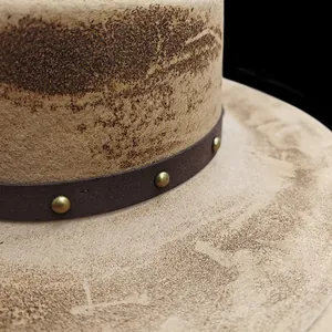 Macro detail of wool fedora featuring vintage textures and leather band with brass studs
