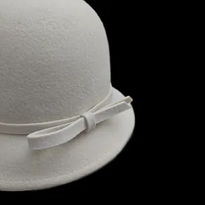Detail of elegant white wool felt hat showing ribbon bow and fine stitching details