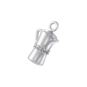 Macro detail of silver moka pot pendant with shimmering zircon pavé stones and ring