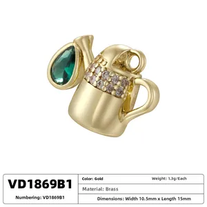 Macro detail of watering can pendant in gold brass with green teardrop gem and diamonds