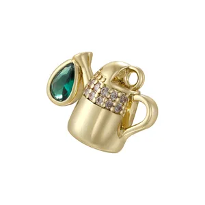 Detailed view of watering can pendant with green teardrop stone and crystal pavé accents