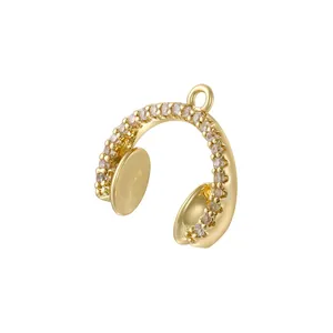 Macro shot of gold headphone pendant with sparkling cubic zirconia on white background