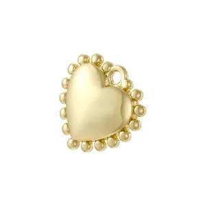 Detailed view of polished gold heart charm with decorative beaded edges for jewelry