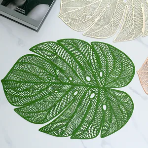 Close-up of green monstera leaf placemat with intricate hollowed-out vein details