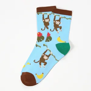 Detail of cotton crew socks showing cartoon monkey and tropical floral patterns