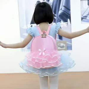 Toddler girl wearing pink ballet backpack with bow and lace detail in a studio setting